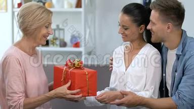 可爱的一对夫妇向婆婆赠送礼物盒，庆祝父母的生日